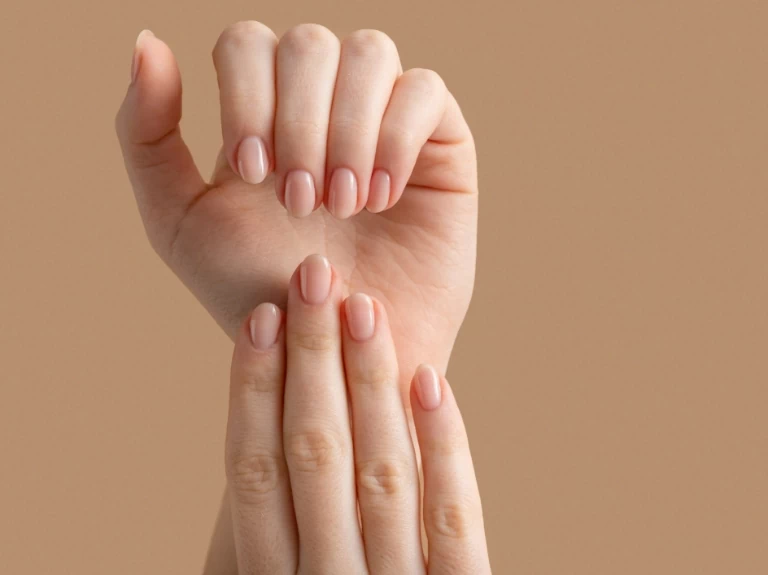 Kobiecie dłonie z pomalowanymi paznokciami